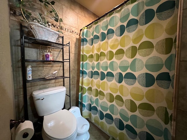 3717 S County Rd 1314, Odessa, TX 79765 - bathroom featuring toilet, a shower with shower curtain, and tile walls