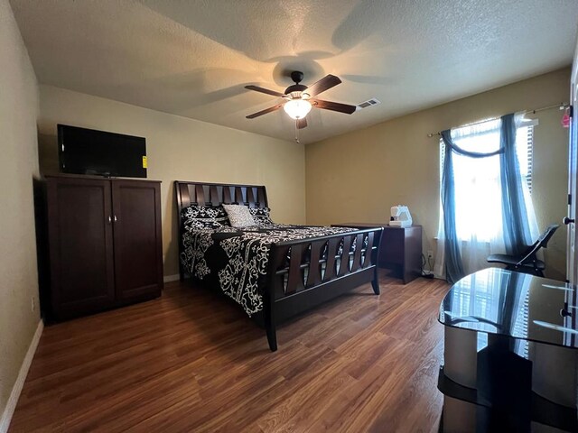 3717 S County Rd 1314, Odessa, TX 79765 - bedroom featuring wood finished floors, baseboards, a ceiling fan, and a textured ceiling