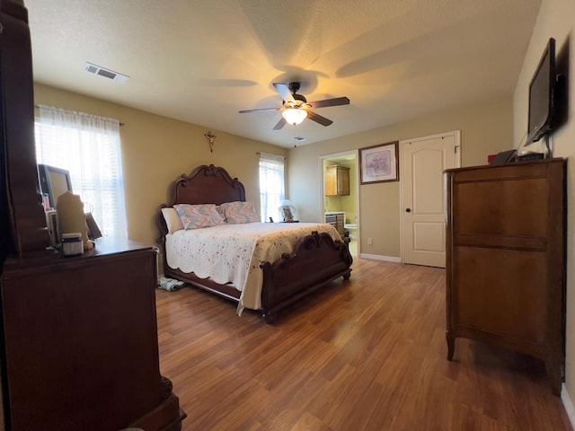 3717 S County Rd 1314, Odessa, TX 79765 - bedroom featuring wood finished floors, ceiling fan, baseboards, and ensuite bathroom