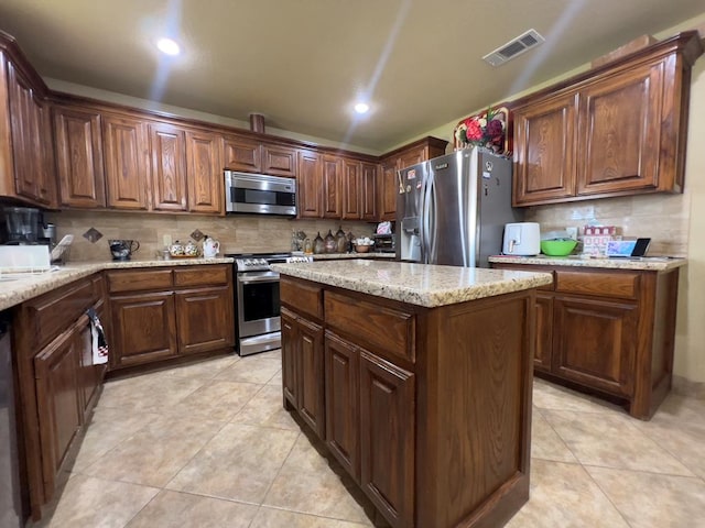 3717 S County Rd 1314, Odessa, TX 79765 - kitchen with stainless steel appliances, decorative backsplash, light tile patterned floors, light stone counters, and recessed lighting