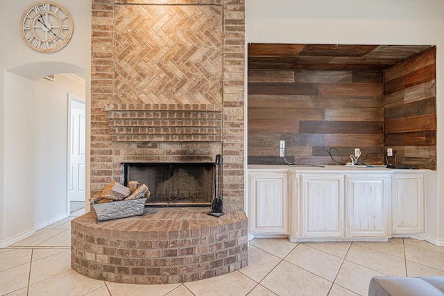 10901 E County Rd 108, Midland, TX 79706 - unfurnished living room featuring light tile patterned floors, arched walkways, a fireplace, and baseboards