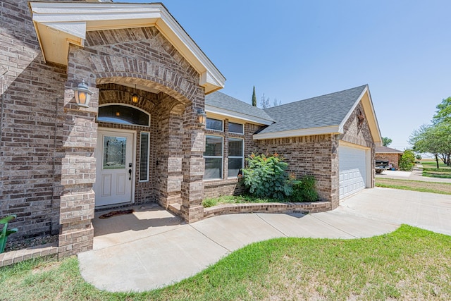 10901 E County Rd 108, Midland, TX 79706 - property entrance featuring brick siding, a shingled roof, driveway, and an attached garage