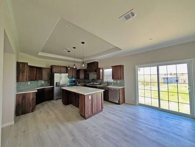 9 Prairie View Ln, Alpine, TX 79830 - kitchen featuring stainless steel appliances, a raised ceiling, light countertops, decorative backsplash, and a kitchen island