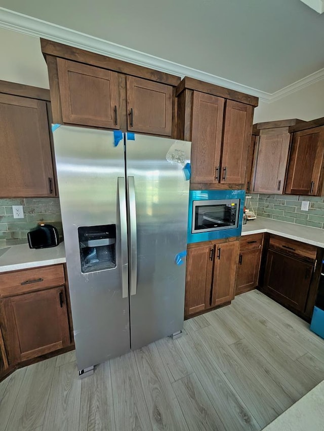 9 Prairie View Ln, Alpine, TX 79830 - kitchen featuring stainless steel appliances, tasteful backsplash, light wood-style floors, ornamental molding, and light countertops