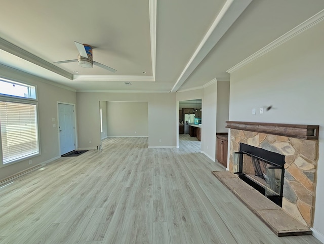 9 Prairie View Ln, Alpine, TX 79830 - unfurnished living room with a tray ceiling, ceiling fan, a fireplace, light wood-type flooring, and ornamental molding