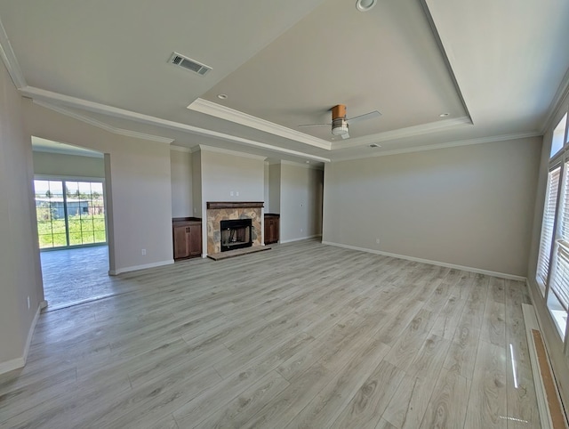 9 Prairie View Ln, Alpine, TX 79830 - unfurnished living room featuring a raised ceiling, healthy amount of natural light, light wood-type flooring, and crown molding