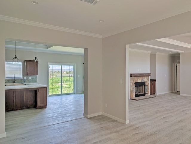 9 Prairie View Ln, Alpine, TX 79830 - kitchen featuring light wood-style floors, crown molding, light countertops, open floor plan, and tasteful backsplash