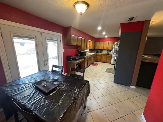 4417 Redbud Ave, Odessa, TX 79762 - dining area with light tile patterned floors, french doors, and a textured ceiling