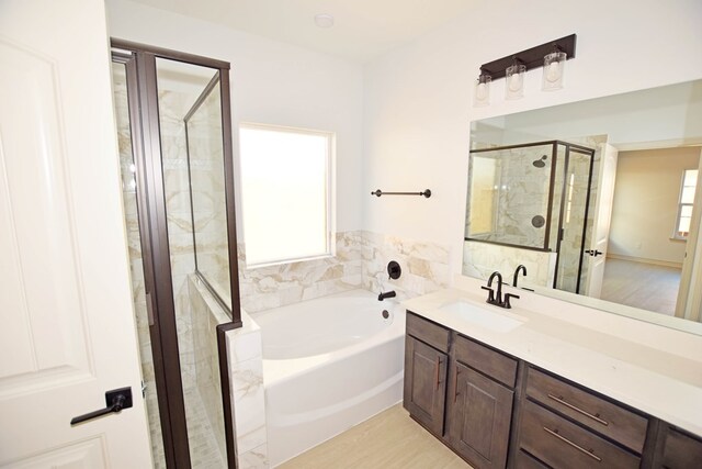 8639 Fortuna Ct, Odessa, TX 79765 - full bathroom with a garden tub, a stall shower, vanity, and wood finished floors
