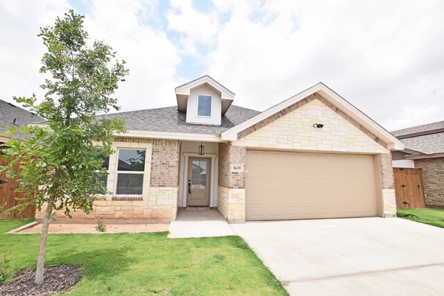 8639 Fortuna Ct, Odessa, TX 79765 - view of front of property with roof with shingles, a garage, driveway, stone siding, and brick siding