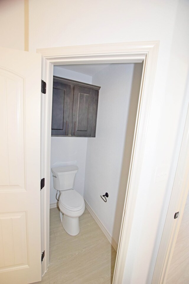 8639 Fortuna Ct, Odessa, TX 79765 - bathroom with toilet, baseboards, and wood finished floors