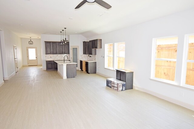 8639 Fortuna Ct, Odessa, TX 79765 - unfurnished living room featuring healthy amount of natural light, baseboards, light wood-style flooring, and a ceiling fan