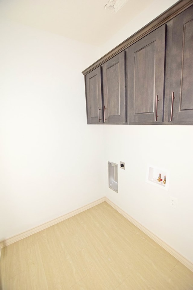 8639 Fortuna Ct, Odessa, TX 79765 - laundry area featuring hookup for an electric dryer, hookup for a washing machine, cabinet space, light wood-style flooring, and baseboards