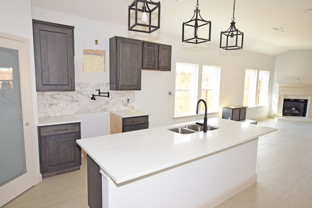 8639 Fortuna Ct, Odessa, TX 79765 - kitchen with a sink, dark brown cabinetry, backsplash, light countertops, and light wood finished floors