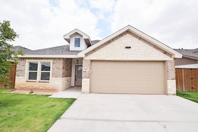 8639 Fortuna Ct, Odessa, TX 79765 - view of front facade with stone siding, an attached garage, driveway, roof with shingles, and brick siding