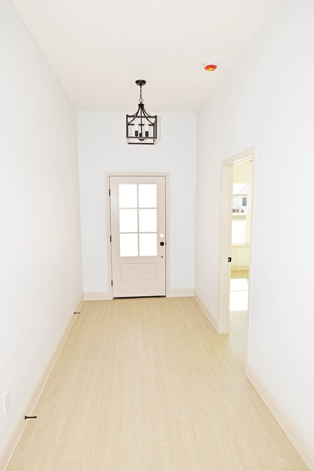 8639 Fortuna Ct, Odessa, TX 79765 - doorway with light wood-style floors, a chandelier, and baseboards