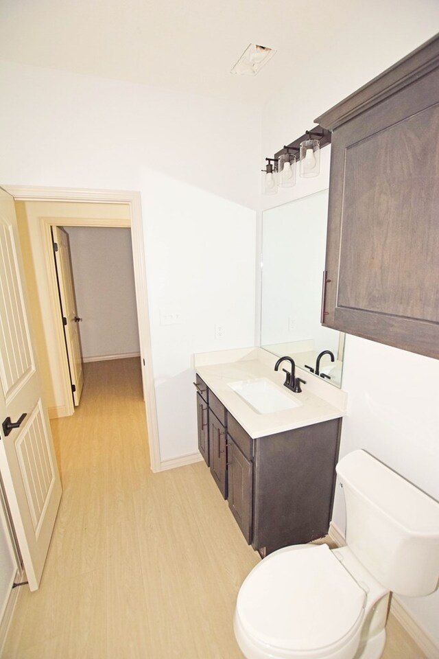 8639 Fortuna Ct, Odessa, TX 79765 - bathroom with wood finished floors, vanity, toilet, and baseboards
