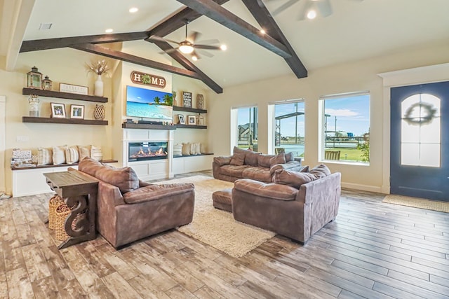 living room featuring ceiling fan, lofted ceiling with beams, and light wood-type flooring