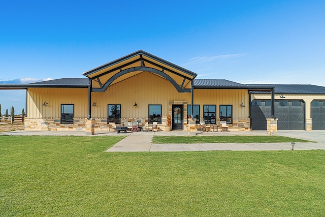 back of property featuring a lawn and a garage