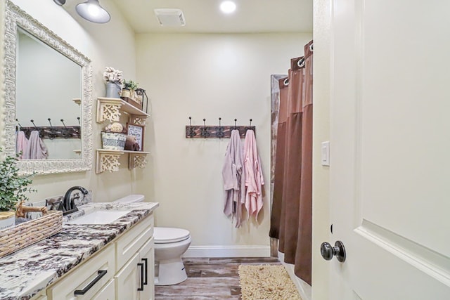 bathroom featuring wood-type flooring, vanity, toilet, and a shower with curtain