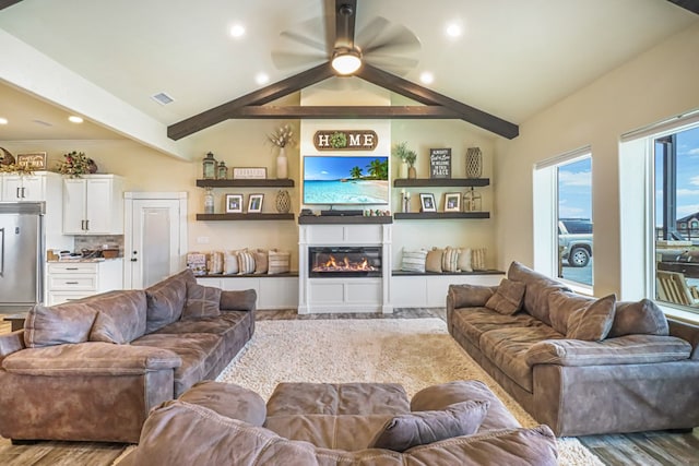 living room with vaulted ceiling with beams, ceiling fan, and light hardwood / wood-style floors