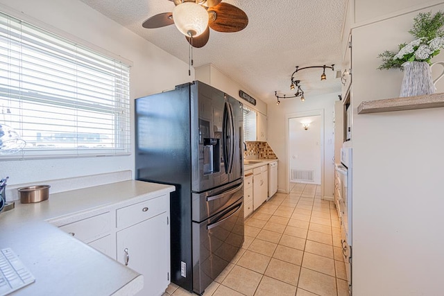 kitchen with white appliances, a textured ceiling, light tile patterned flooring, light countertops, and a ceiling fan
