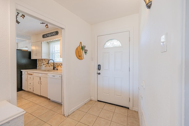 foyer entrance with light tile patterned floors, plenty of natural light, and baseboards