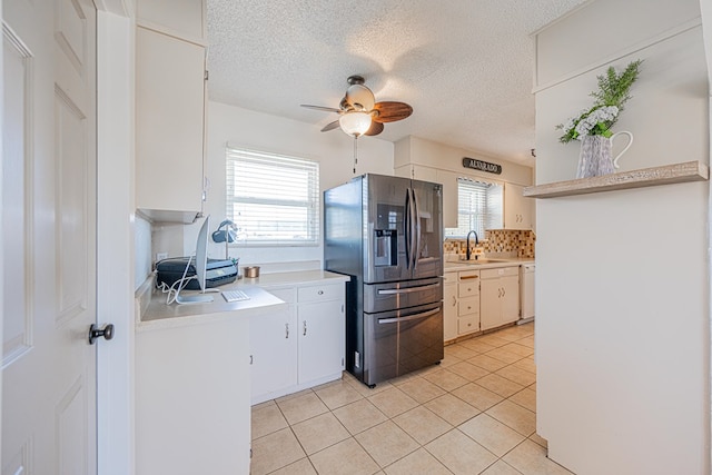 kitchen featuring stainless steel fridge, a sink, light countertops, a ceiling fan, and light tile patterned floors