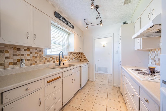 kitchen with white appliances, a sink, under cabinet range hood, light tile patterned floors, and light countertops