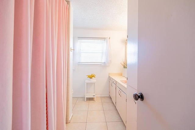 bathroom featuring tile patterned flooring, vanity, and a textured ceiling