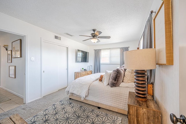 bedroom featuring a textured ceiling, ceiling fan, and a closet