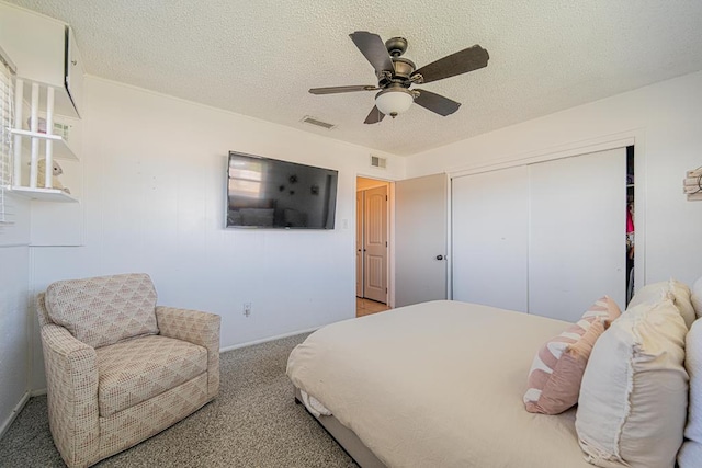 bedroom with a closet, baseboards, a textured ceiling, carpet floors, and a ceiling fan
