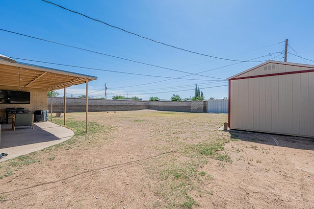 fenced backyard featuring a patio, a storage unit, and an outbuilding