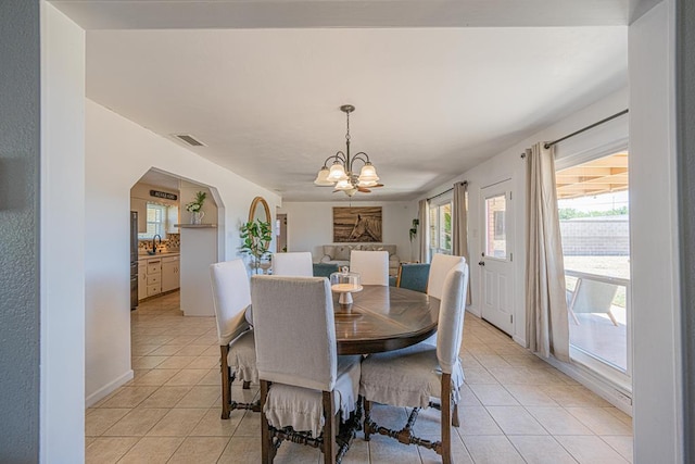 dining space featuring light tile patterned floors and a chandelier