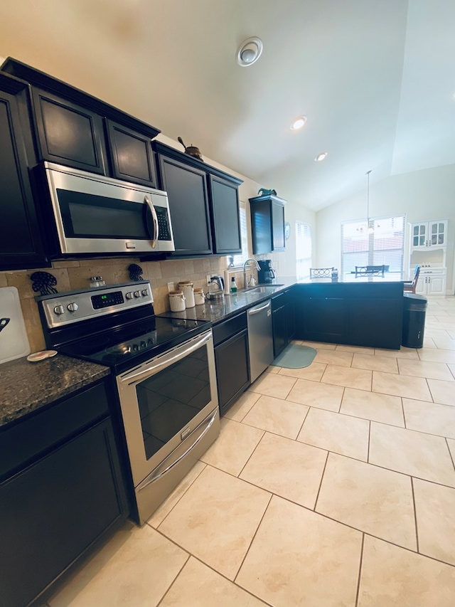 808 Brittlebush Ct, Odessa, TX 79765 - kitchen with stainless steel appliances, tasteful backsplash, a sink, vaulted ceiling, and dark stone counters