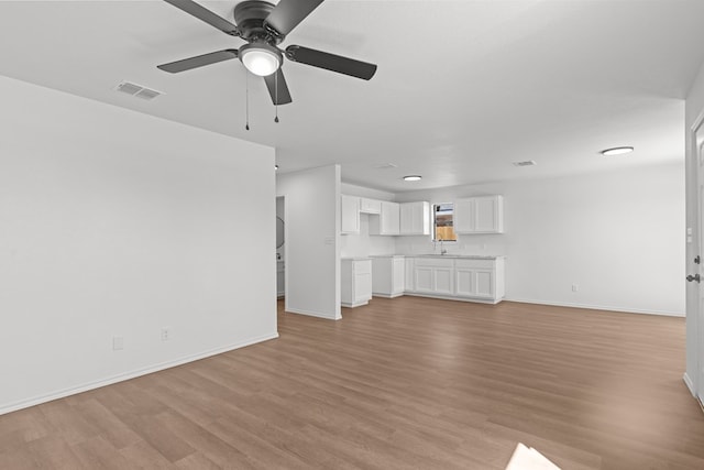 unfurnished living room featuring ceiling fan, baseboards, visible vents, and light wood-style flooring