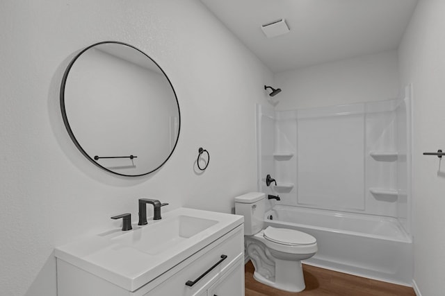 full bath with shower / bath combination, vanity, toilet, and wood finished floors