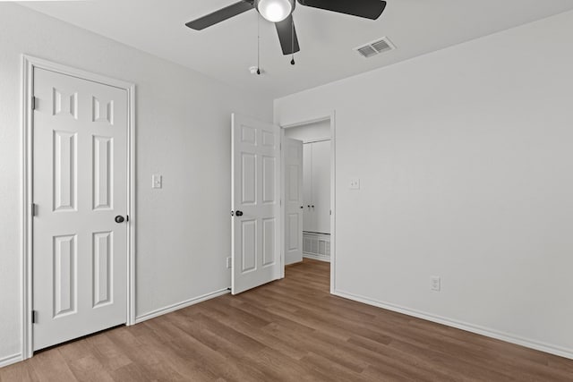 unfurnished bedroom featuring visible vents, baseboards, and wood finished floors