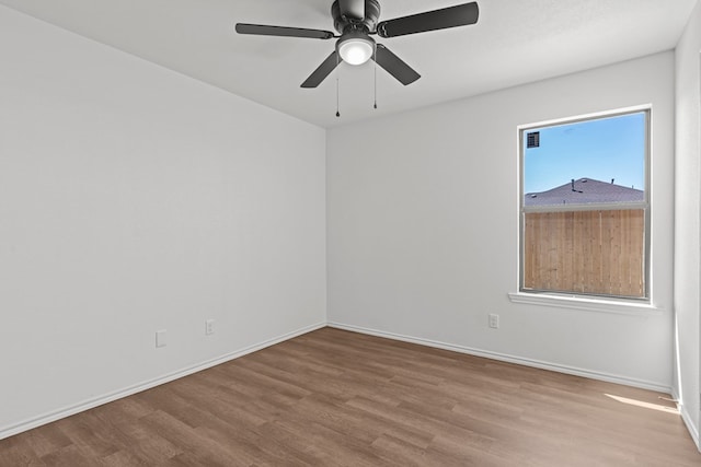 empty room featuring baseboards, ceiling fan, and wood finished floors