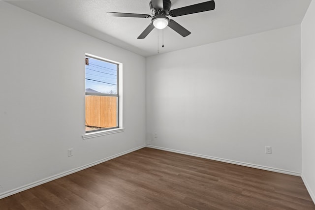 empty room with dark wood-style flooring, baseboards, and ceiling fan