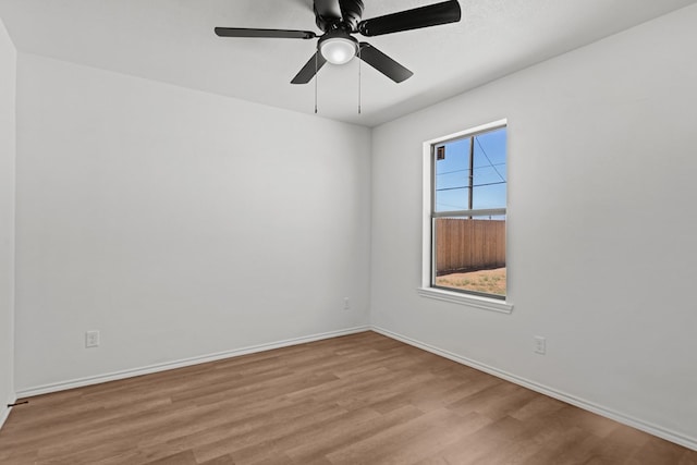 empty room featuring baseboards, ceiling fan, and wood finished floors