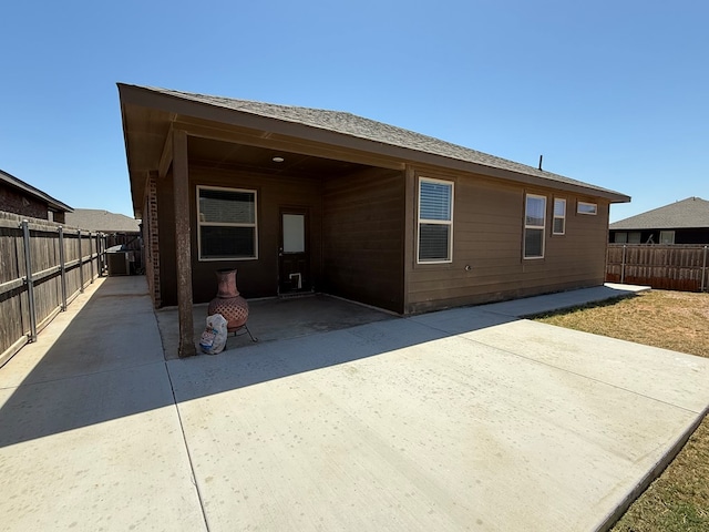 rear view of property featuring a fenced backyard, a patio, and central air condition unit