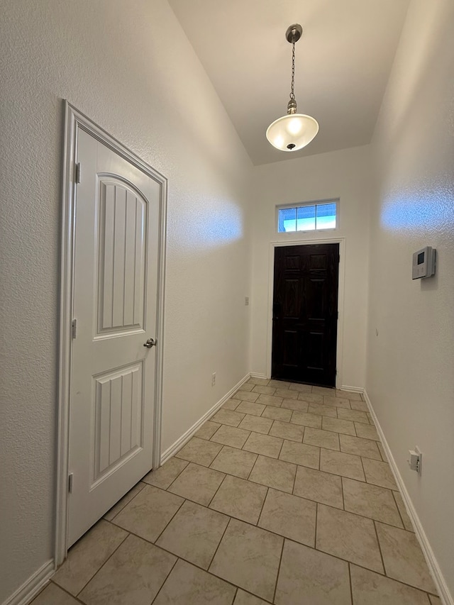 entrance foyer featuring light tile patterned floors and vaulted ceiling