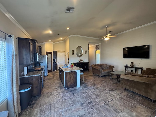 6981 King Ranch Rd, Odessa, TX 79765 - kitchen featuring stainless steel appliances, open floor plan, ornamental molding, an island with sink, and a breakfast bar area