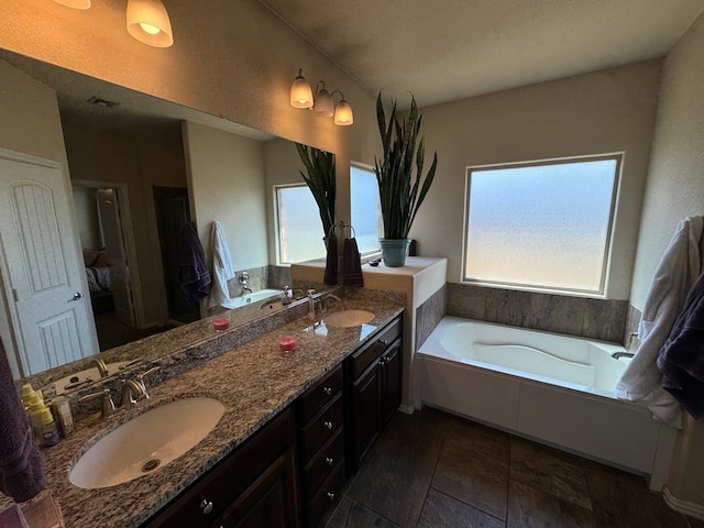 6981 King Ranch Rd, Odessa, TX 79765 - full bathroom featuring double vanity, a bath, and stone tile floors