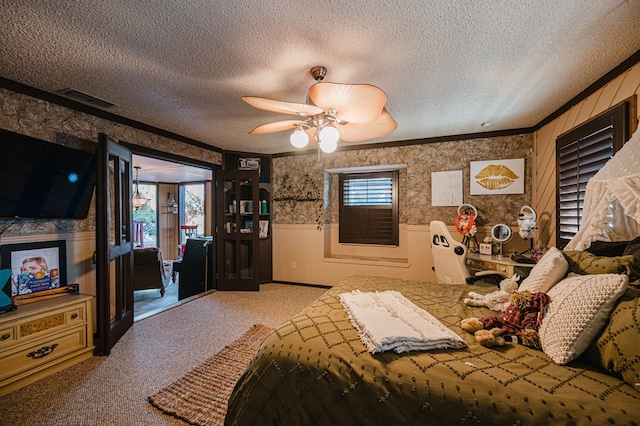 bedroom featuring carpet, ceiling fan, crown molding, and a textured ceiling