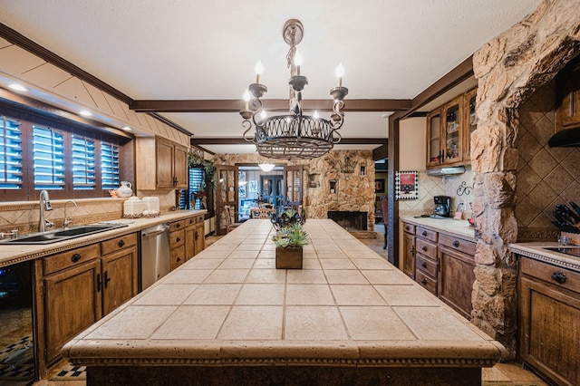 kitchen featuring tasteful backsplash, sink, pendant lighting, beam ceiling, and a center island