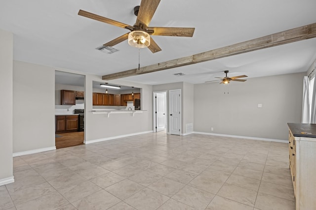 unfurnished living room with beamed ceiling, ceiling fan, and light tile patterned flooring