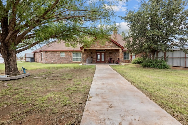 4975 SE 3000, Andrews, TX 79714 - view of front of house featuring brick siding, french doors, a chimney, and concrete driveway