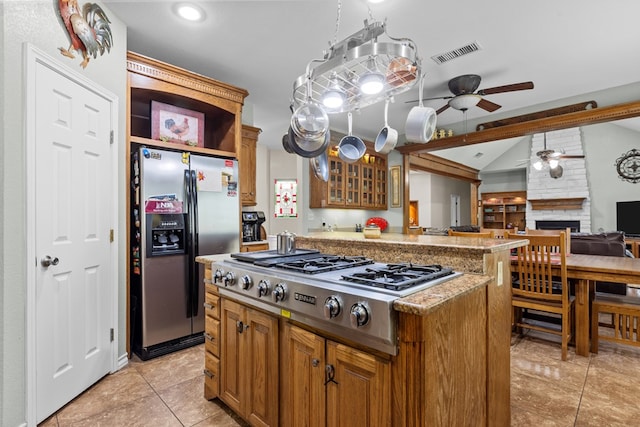 4975 SE 3000, Andrews, TX 79714 - kitchen with appliances with stainless steel finishes, ceiling fan, lofted ceiling, brown cabinetry, and glass insert cabinets